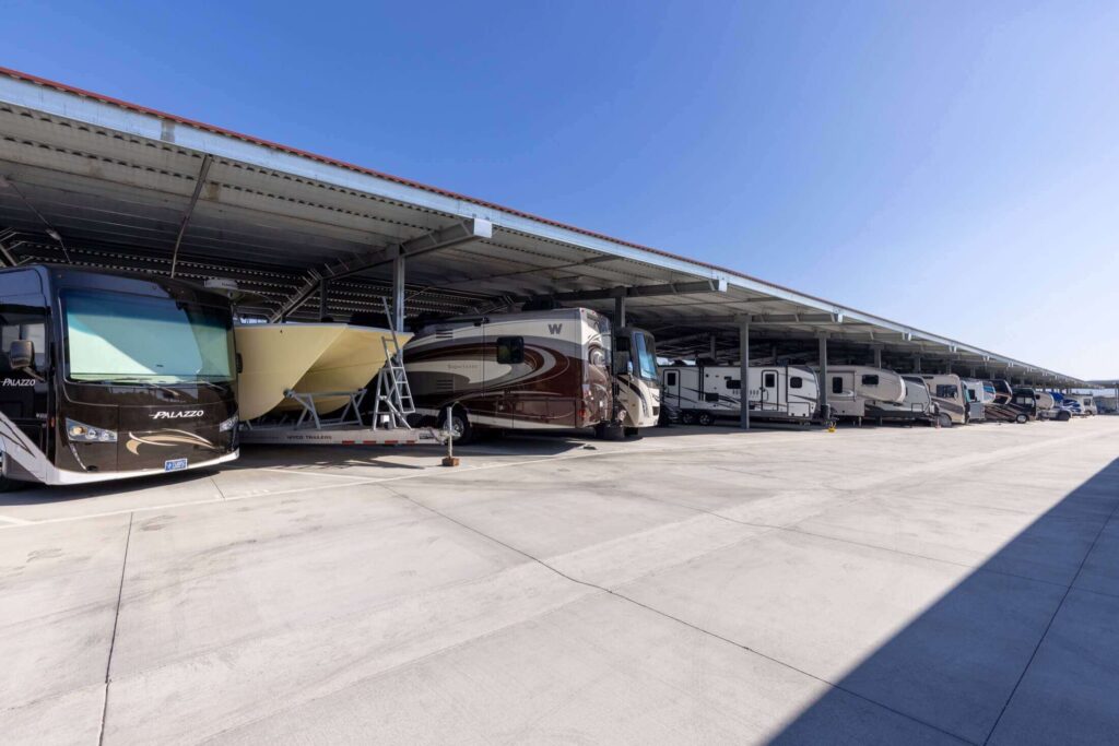 row of boats and rvs in covered parking spaces